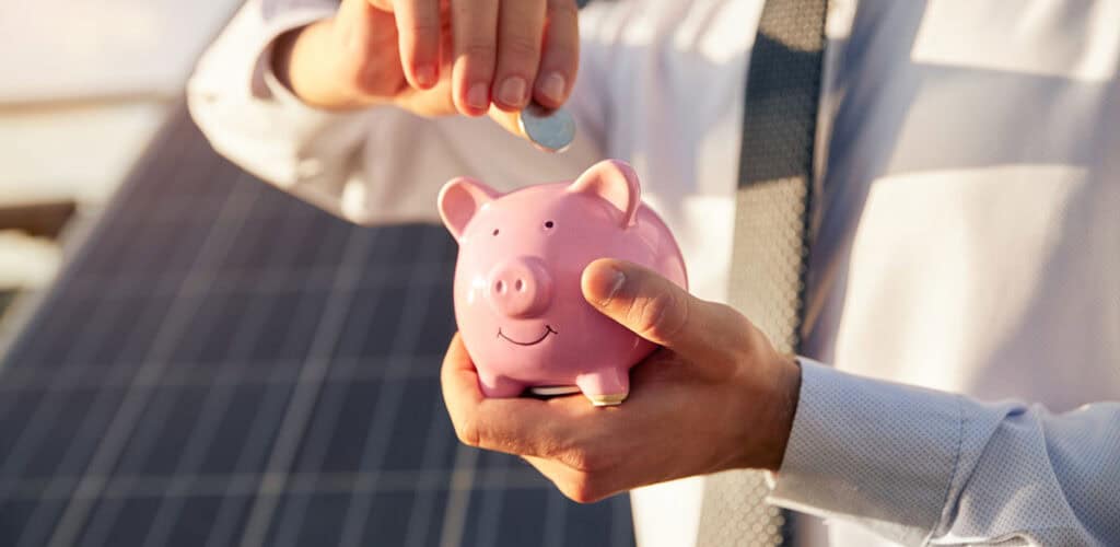 Piggy bank in front of solar panels