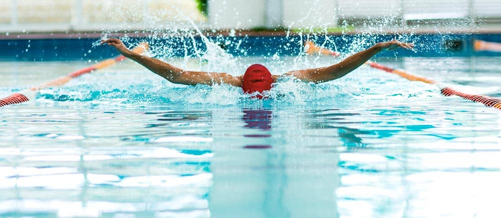 man swimming in olympic pool