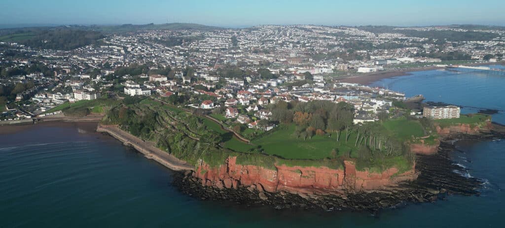 Roundham Head, Torbay, South Devon, England: DRONE VIEW: Roundham Head, Goodrington Sands, the town of Paignton and Paignton